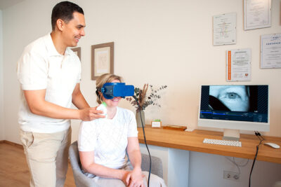 Ausbildung zur Schwindeltherapie Therapeut setzt seiner Patientin mit Schwindel eine Nystagmusbrille auf